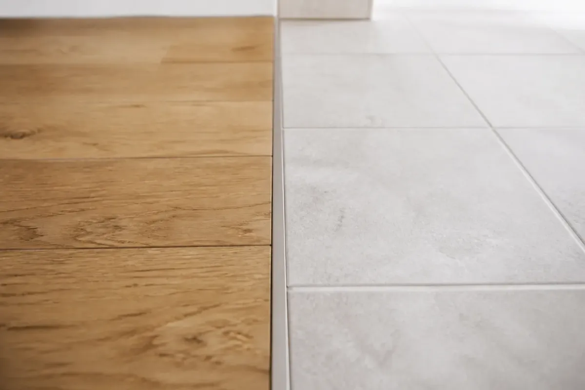 Parquet d'un côté et carrelage de l'autre, raccordés au même niveau par une fine finition centrale